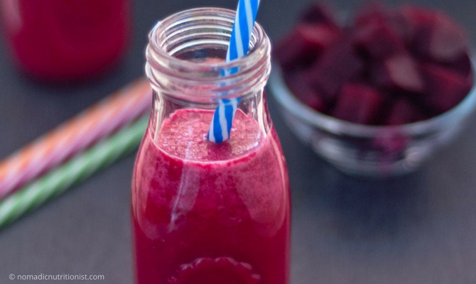 Red beet shake in small bottle with blue & white straw