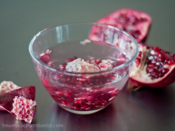 Pomegranate seeds in a bowl of water