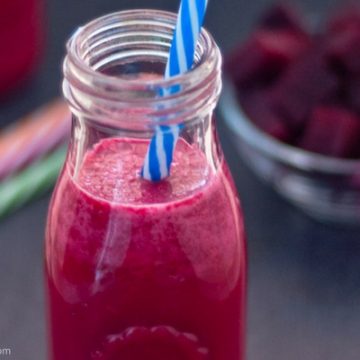 Red beet shake in small bottle with blue & white straw