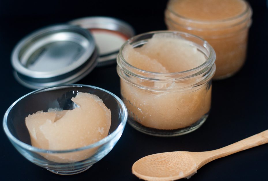 Thick Irish Moss gel in a bowl and small jar on a black table with a wooden spoon beside it. In the background is a jar of thinner consistency Irish Moss.