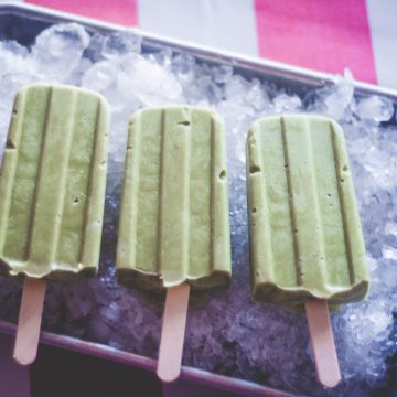 3 Avocado Match Popsicles on a tray filled with ice
