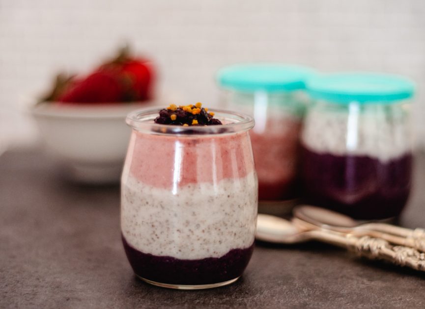 A small jar of pureed strawberry, coconut and blueberry chia pudding