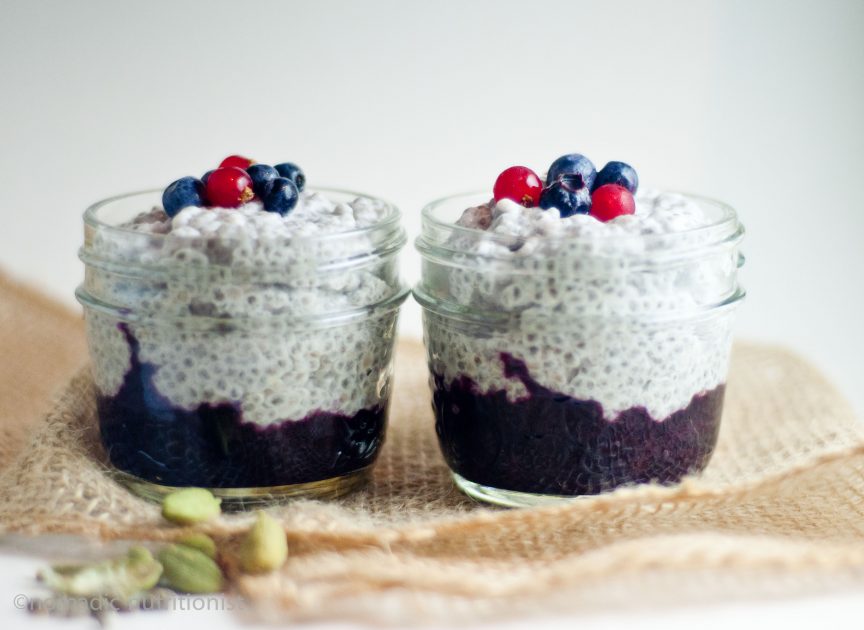 Two small mason jars with coconut cardamon chia pudding with blueberry compote