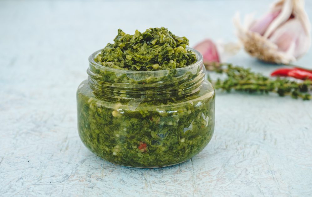 A small glass jar of green seasoning