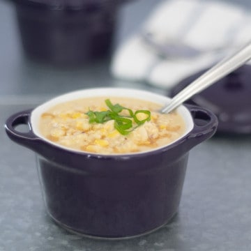 Chinese Trinidadian corn soup in a small purple bowl with a spoon