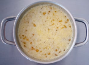 A saucepan with melted butter with foam on top as it cooks down