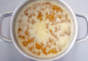 A saucepan with melted butter and foam on top to be scooped off