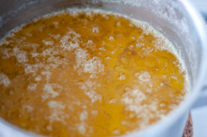 A saucepan with melted butter with milk solids cooked out on the bottom of the pan
