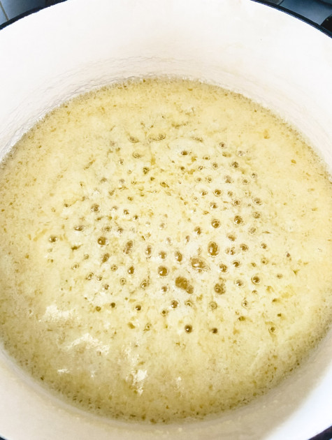 A saucepan with butter cooking on low heat and foam rising to the top