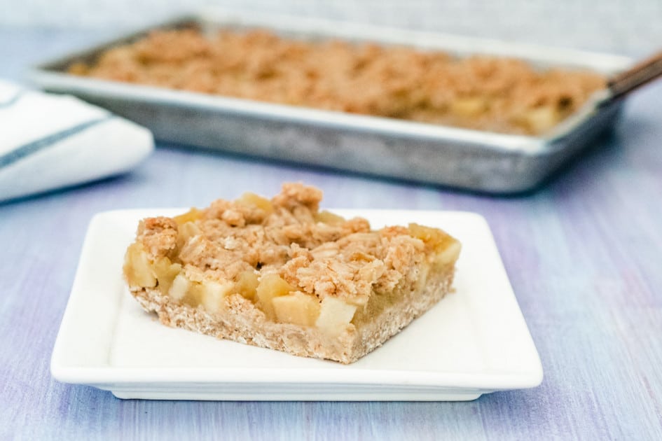 A piece of apple butter oatmeal bar on a square white plate