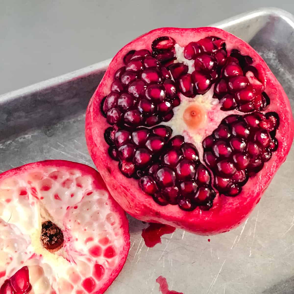 An overhead shot of a pomegranate with the top cut off exposing the arils