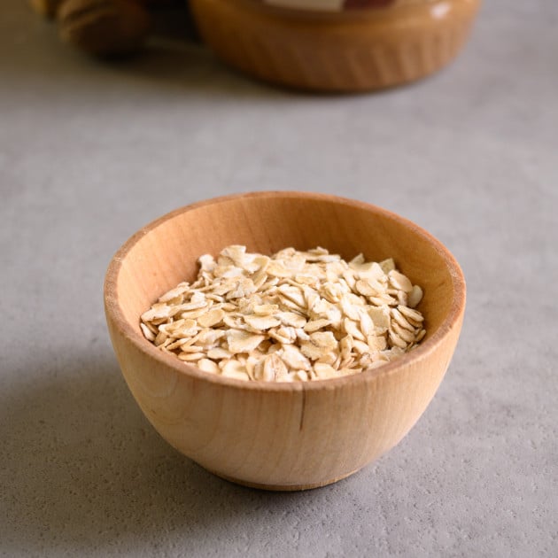 A small wooden bowl with toasted flaked oats.